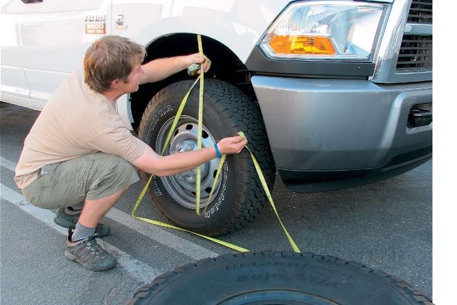 A man measuring for bigger tires for a truck