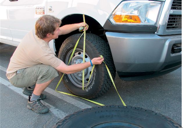 A man measuring for bigger tires for a truck